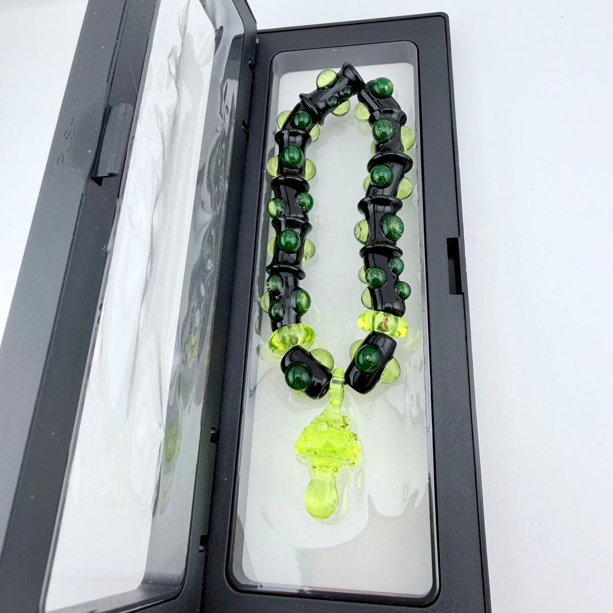 Stretchy Black Glass Bracelet with Green dots that Glow Bright Under Black Light - JeffBeckerGlass.com