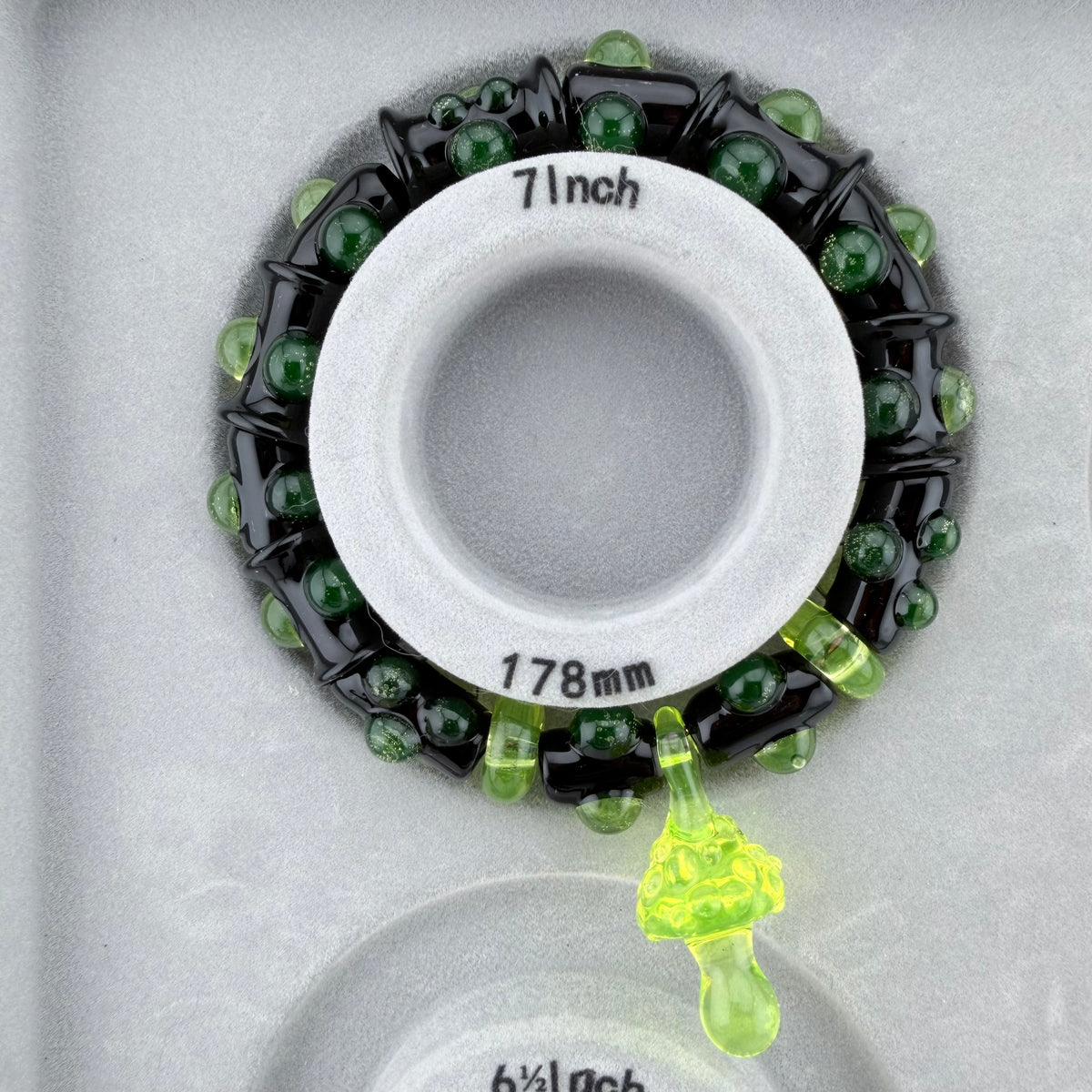 Stretchy Black Glass Bracelet with Green dots that Glow Bright Under Black Light - JeffBeckerGlass.com