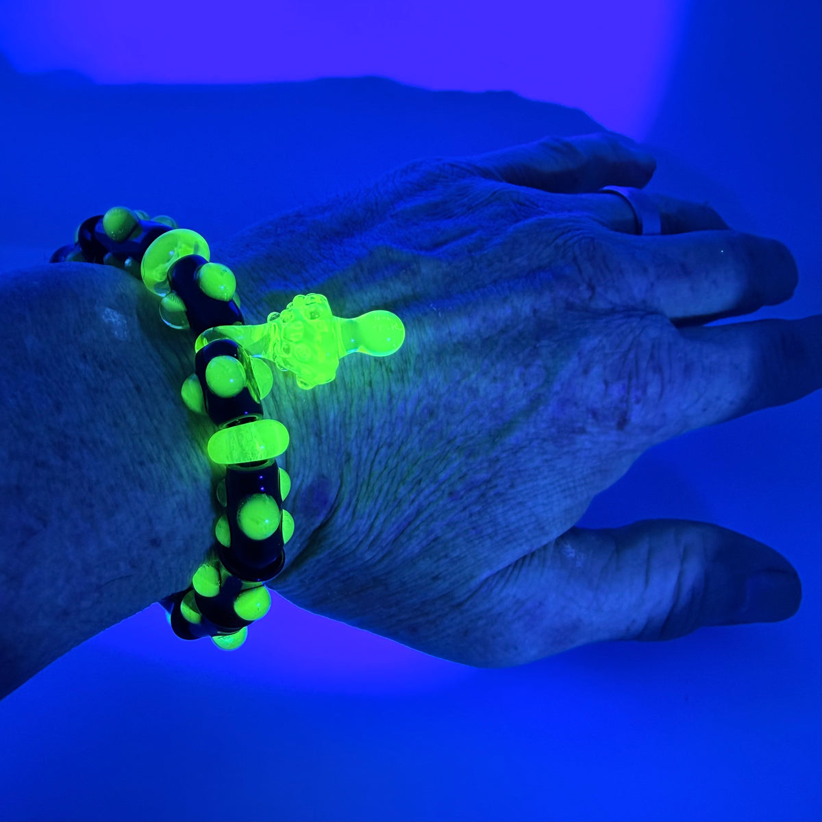 Stretchy Black Glass Bracelet with Green dots that Glow Bright Under Black Light - JeffBeckerGlass.com