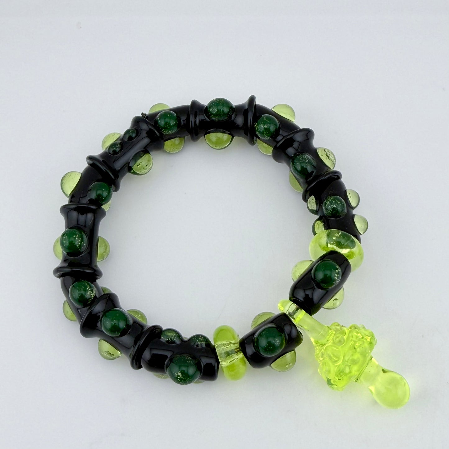Stretchy Black Glass Bracelet with Green dots that Glow Bright Under Black Light - JeffBeckerGlass.com