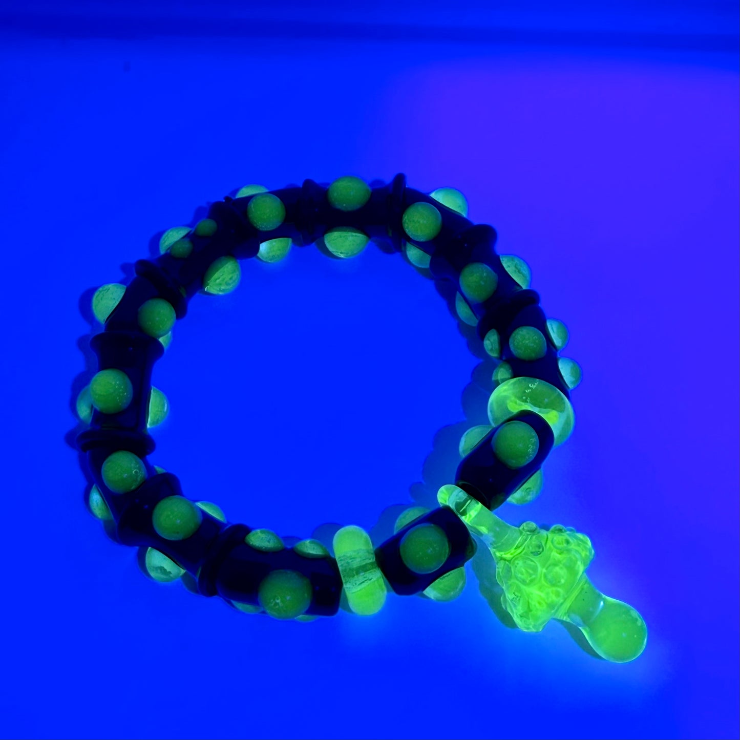 Stretchy Black Glass Bracelet with Green dots that Glow Bright Under Black Light - JeffBeckerGlass.com