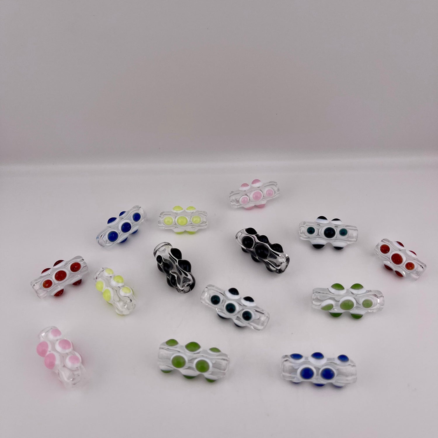 Clear Glass Barrel Bead with Colored glass marbles over white