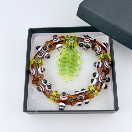 Stretchy Amber Glass Bracelet with Leaf and dots that Glow Bright Green Under Black Light - JeffBeckerGlass.com
